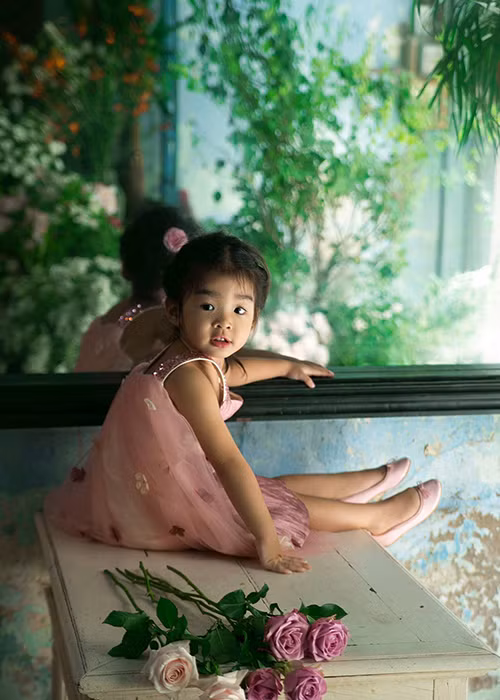 Con gái Xuân Lan khoe vẻ đáng yêu trong chiếc váy tông hồng ngọt ngào chụp ảnh bên những bông hoa hồng.