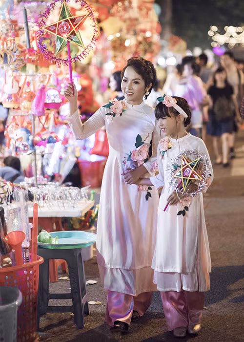 Con gái đầu lòng của Thái Thùy Linh diện áo dài và xuống phố Hàng Mã chọn mua những chiếc đèn lồng Trung thu. Ảnh: Pháp luật Việt Nam