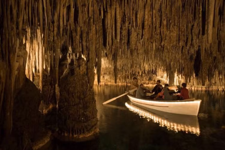 Các nhạc công chơi nhạc khi di chuyển qua hang động Cuevas del Drach trên đảo Majorca, Tây Ban Nha.