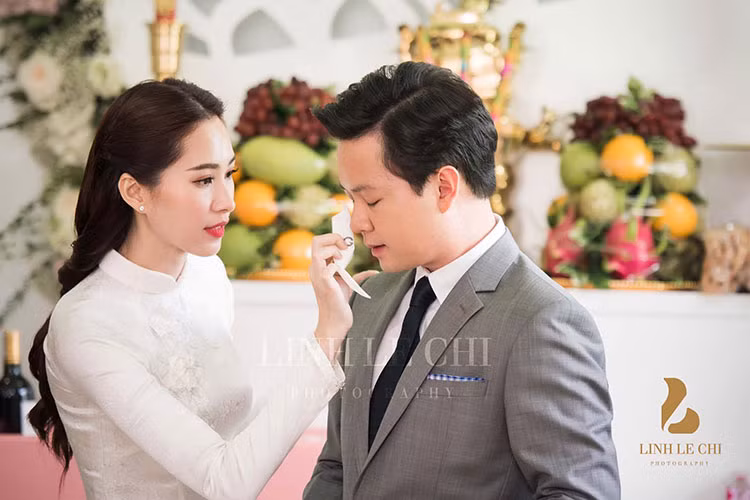 Trong lễ ăn hỏi, Hoa hậu Việt Nam 2012 ân cần quan tâm, chăm sóc hôn phu. Ảnh: Lê Chí Linh