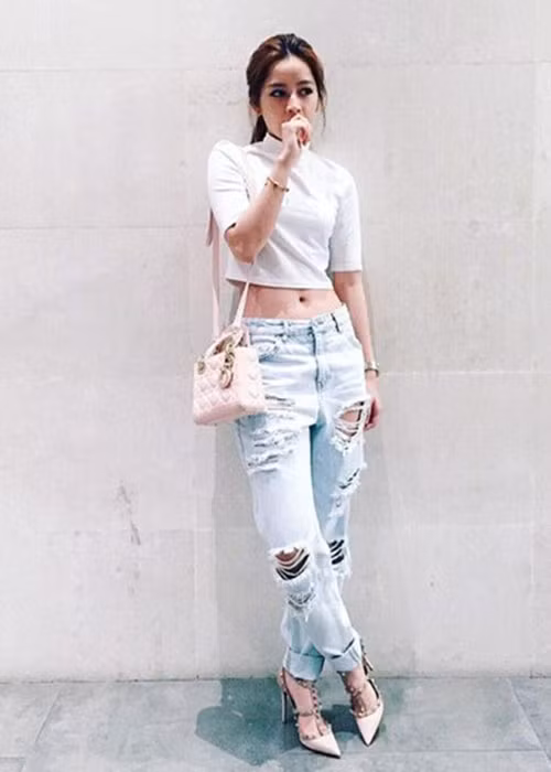Cựu hot girl sinh năm 1993 trẻ trung, quyến rũ khi kết hợp áo crop top, quần jeans rách, túi và xăng đan. Ảnh: Vietnamnet