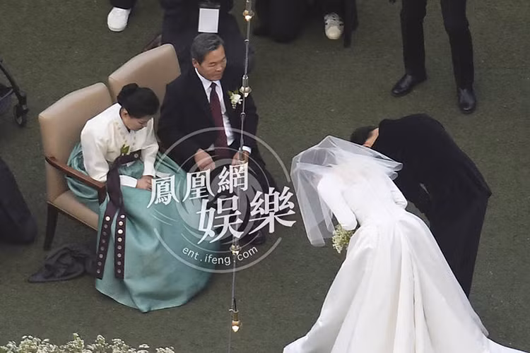Cặp Song - Song cúi gập người bày tỏ lòng biết ơn với 2 đấng sinh thành. Ảnh: Ifeng