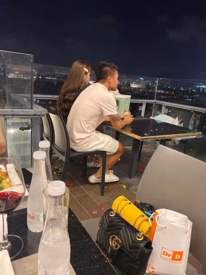 Trong ảnh, Quang Hải diện áo phông màu hồng nhạt, quần trắng, giày cũng trắng, đối lập hẳn với bộ đồ màu đen của bạn gái.