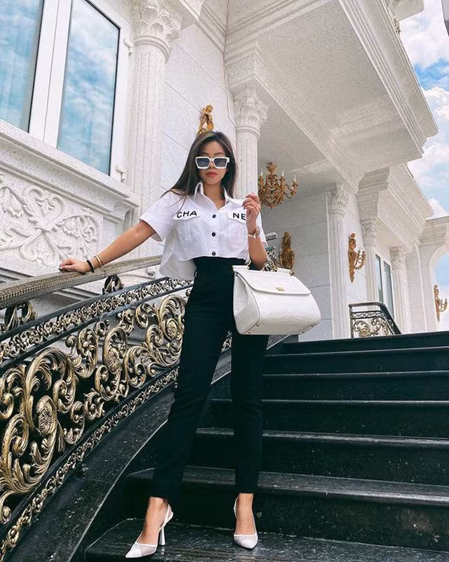 Trong hình Tiên Nguyễn là một người sành mặc khi diện một thiết kế áo croptop từ thương hiệu Chanel phối cùng giày cao gót cùng màu trắng, thêm chiếc túi hiệu size lớn yêu thích. Màu trắng cô mặc lại vô tình tiệp đồng màu cùng với sơn tường nhà cô. Nhằm tăng thêm chiều cao cũng như tạo hiệu ứng phần eo nhỏ lại, cô nàng còn khéo léo mặc một chiếc áo thun màu đen bên trong: không cần hở rốn vẫn vô cùng trendy.