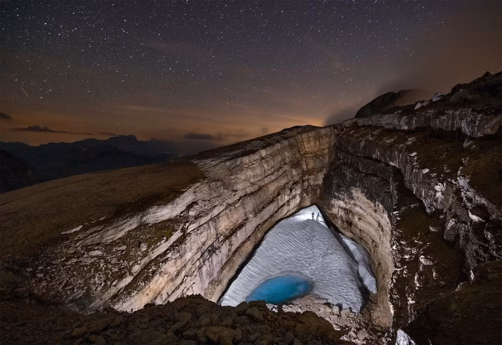 Tuyết mùa đông tan chảy lấp đầy vùng trũng trên dãy núi Dolomite Alps (đông bắc Italia), nơi từng có một hồ nước quanh năm. Vào năm 1994, các nhà thám hiểm người Ý phát hiện ra rằng hồ đã biến mất - do lớp băng bịt một lỗ ở đáy đã tan chảy, cho phép nước thoát qua một trục hẹp vào một hang động băng sâu 285 mét. Ảnh: National Geographic