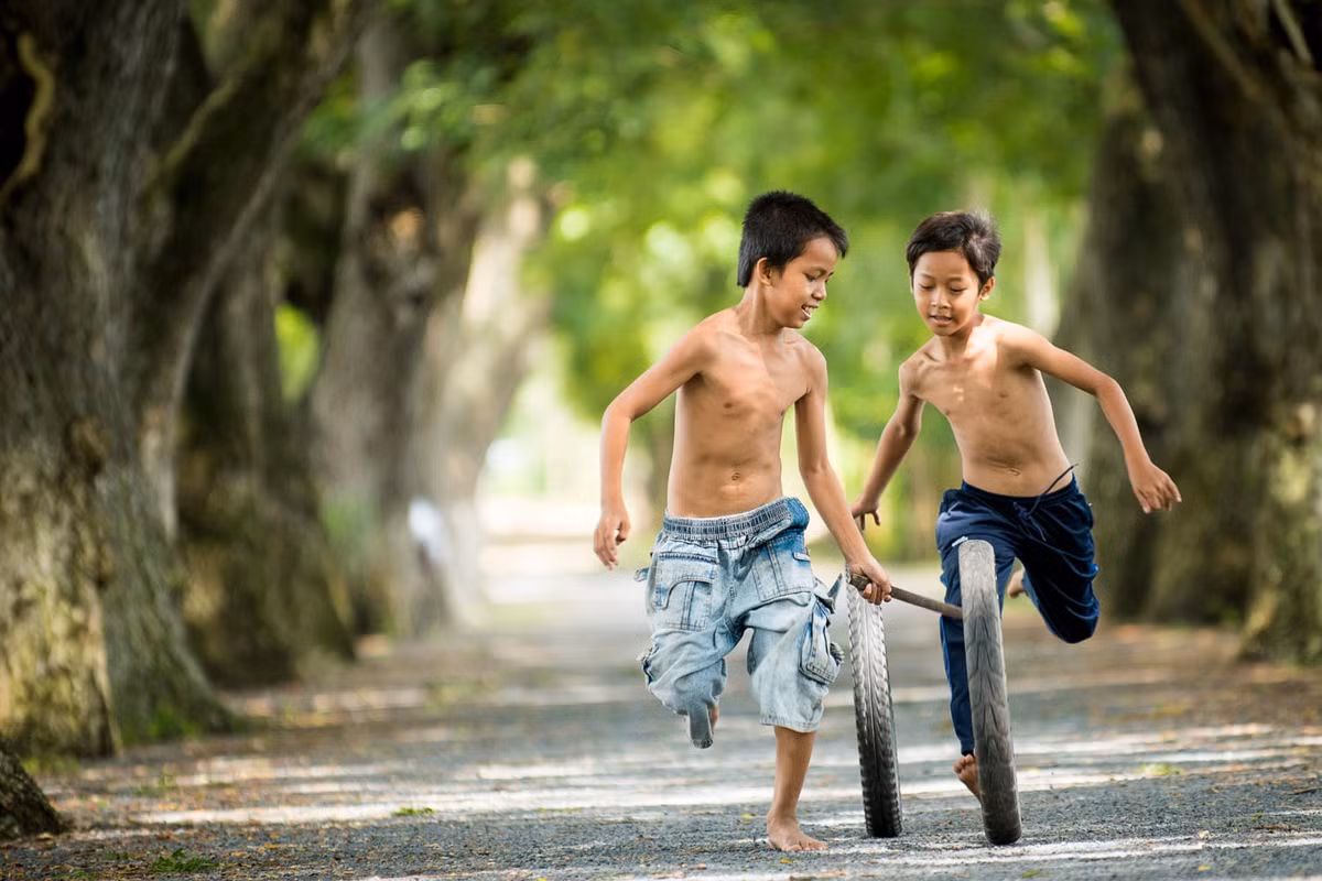 Hai cậu bé chơi đùa trên đường làng. Ảnh: Raymond Low - 500px.com