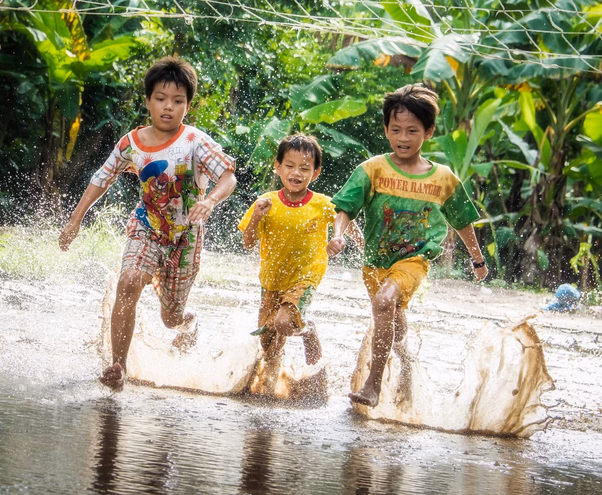 Trẻ em chơi đùa trên đường làng ngập nước ở Tây Ninh. Ảnh: Raymond Low - 500px.com