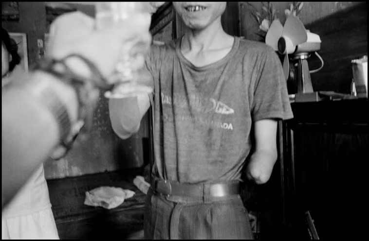Người thương binh Việt Nam mời nhiếp ảnh gia nếm thử rượu gạo. Ảnh: Larry Towell - Magnumphotos.com