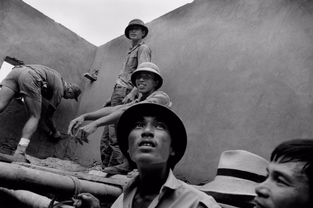 Cựu binh Mỹ Chuck Nixon tham gia xây dựng một bệnh xá từng bị bom Mỹ phá hủy thời chiến tranh Việt Nam cùng các công nhân người Việt tại Yên Viên. Ảnh: Larry Towell - Magnumphotos.com