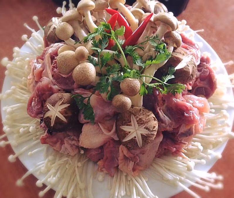 Trong ảnh, chị Ngọc Xuân, một bà nội trợ khéo tay gợi ý kiểu bài trí món ăn rất đẹp mắt bằng cách xếp nấm kim châm ở dưới cùng rồi bày thịt gà và các loại nấm khác lên trên. 