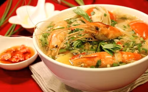 Đun nồi nước sôi thì thả tôm đã ướp gia vị vào. Nước sôi trở lại thì hớt bọt, nêm gia vị, cho dứa vào. Canh chín, rắc hành, mùi, ớt và múc canh ra bát. Món canh dùng nóng, có thể ăn kèm thịt kho, cá kho hoặc các món rau xào. Ảnh: 8monngonmoingay