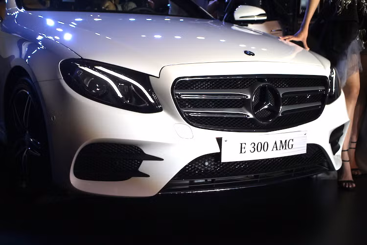 Trong khi đó, phiên bản E300 AMG lại có phần đầu thể thao hơn nhờ lưới tản nhiệt 2 thanh ngang, chia cắt bởi logo Mercedes cỡ lớn nằm ở chính giữa. Ngoài ra, phiên bản này cũng có cản trước với các khe hút gió lớn hơn hẳn so với bản E200.