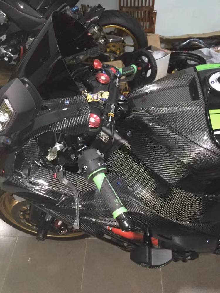 Không chỉ có dàn áo "hàng độc", chiếc siêu môtô ZX-10R này còn được chủ nhân đầu tư cho hàng loạt đồ chơi độc đáo khác. Trên tay lái của chiếc xe là cặp bao tay Progrip 732 chống trơn trượt, trong khi giữa chảng ba là trợ lực lái của Ohlins.