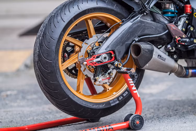 Ở phía sau, bộ gắp nhôm nguyên bản của xe đã được ốp sợi carbon để đem tới dáng vẻ thể thao hơn. Ngoài ra chiếc xe còn có heo Brembo HP Billet và pát tăng xích Lightech. Cây pô Yoshimura R55-LE cùng với cổ pô titan đem tới âm thanh trầm ấm hơn từ khối động cơ 4 xi-lanh của GSX-S1000.