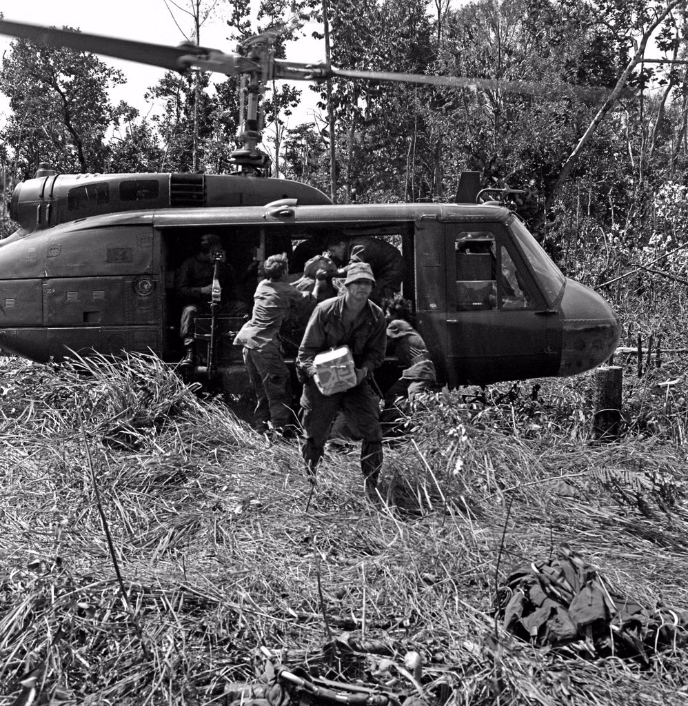 Nhận hàng tiếp tế từ trực thăng UH-1. Ảnh: Conrad Leighton.