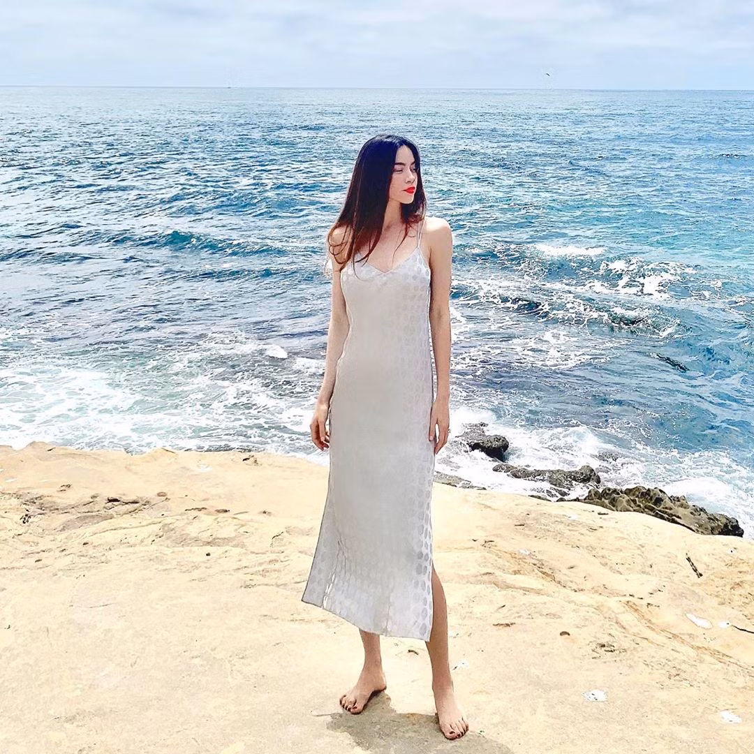 Trong tủ đồ của Hồ Ngọc Hà cũng có những chiếc váy suông dài quá đầu gối. Người đẹp chọn mặc kiểu váy hai dây, xẻ tà hai bên. Kiểu váy này có thể mặc trong nhiều hoàn cảnh như đi biển, dạo phố hoặc dự tiệc.