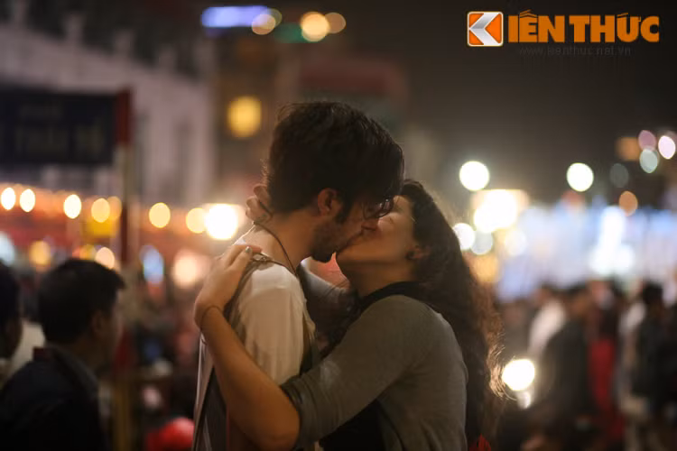 Chuông đồng hồ điểm 0 giờ, đúng lúc quả pháo hoa đầu tiên được bắn lên trời, nhiều cặp đôi người nước ngoài ôm hôn nhau đắm đuối. Ảnh: Dương Hường