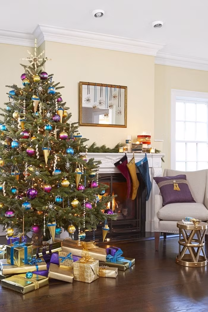 Thay vì sắc đỏ, xanh truyền thống, hãy thử làm mới cây thông Noel nhà mình với đồ trang trí màu tím, vàng đậm chất hiện đại.
