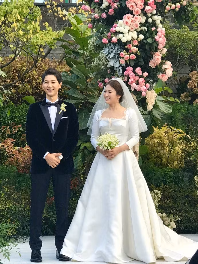 Song Hye Kyo khiến nhiều fan bất ngờ khi xuất hiện xinh đẹp, rạng rỡ trong váy cưới không cầu kỳ cùng lối trang điểm tự nhiên. Ngoài ra, bó hoa trên tay Song Hye Kyo cũng đơn giản. Ảnh: Zing.