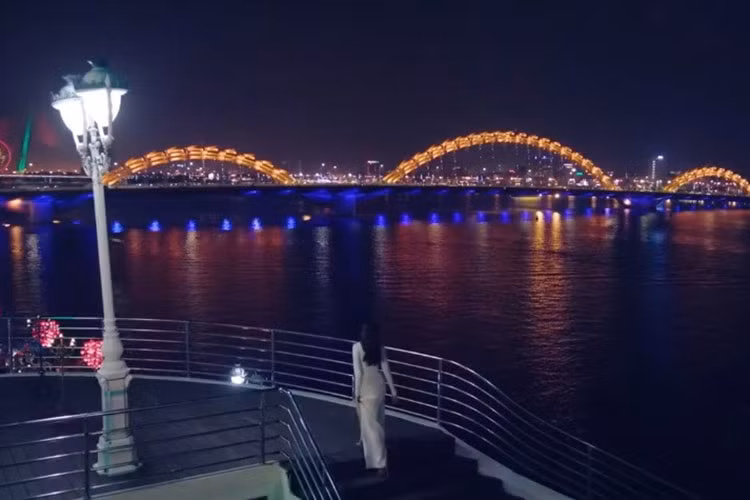 Sông Hàn, một đặc sản của Đà Nẵng. Phạm Hương diện váy lộng lẫy dự tiệc tối tại một nhà hàng bên sông, nhìn ra Cầu Rồng - một biểu tượng của thành phố.