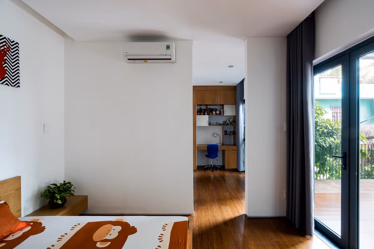 Phòng ngủ nhỏ có cửa lớn hướng ra ban công lấy ánh nắng.