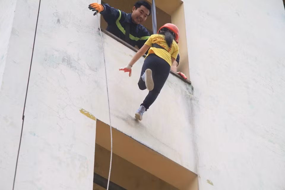 Những bé gái không ngại độ cao đu dây thoát hiểm.
