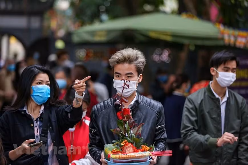 Nhiều bạn trẻ đến chùa Hà lần đầu để cầu duyên nên còn bỡ ngỡ, cần người hướng dẫn cúng bái theo đúng trình tự. (Ảnh: Minh Sơn/Vietnam+)