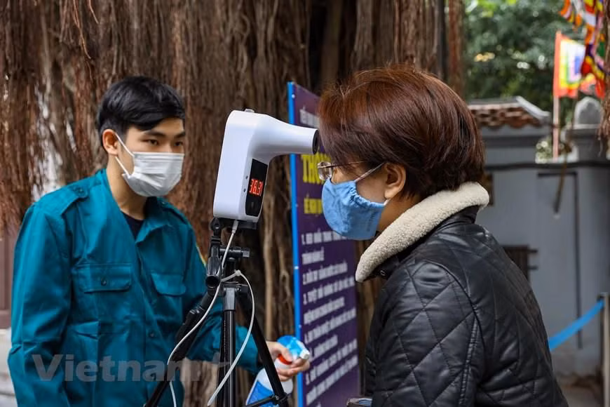 Nhà chùa đã bố trí trước cổng 2 máy đo thân nhiệt để phục vụ nhu cầu đi lễ của người dân tăng cao trong những ngày Tết. (Ảnh: Minh Sơn/Vietnam+)