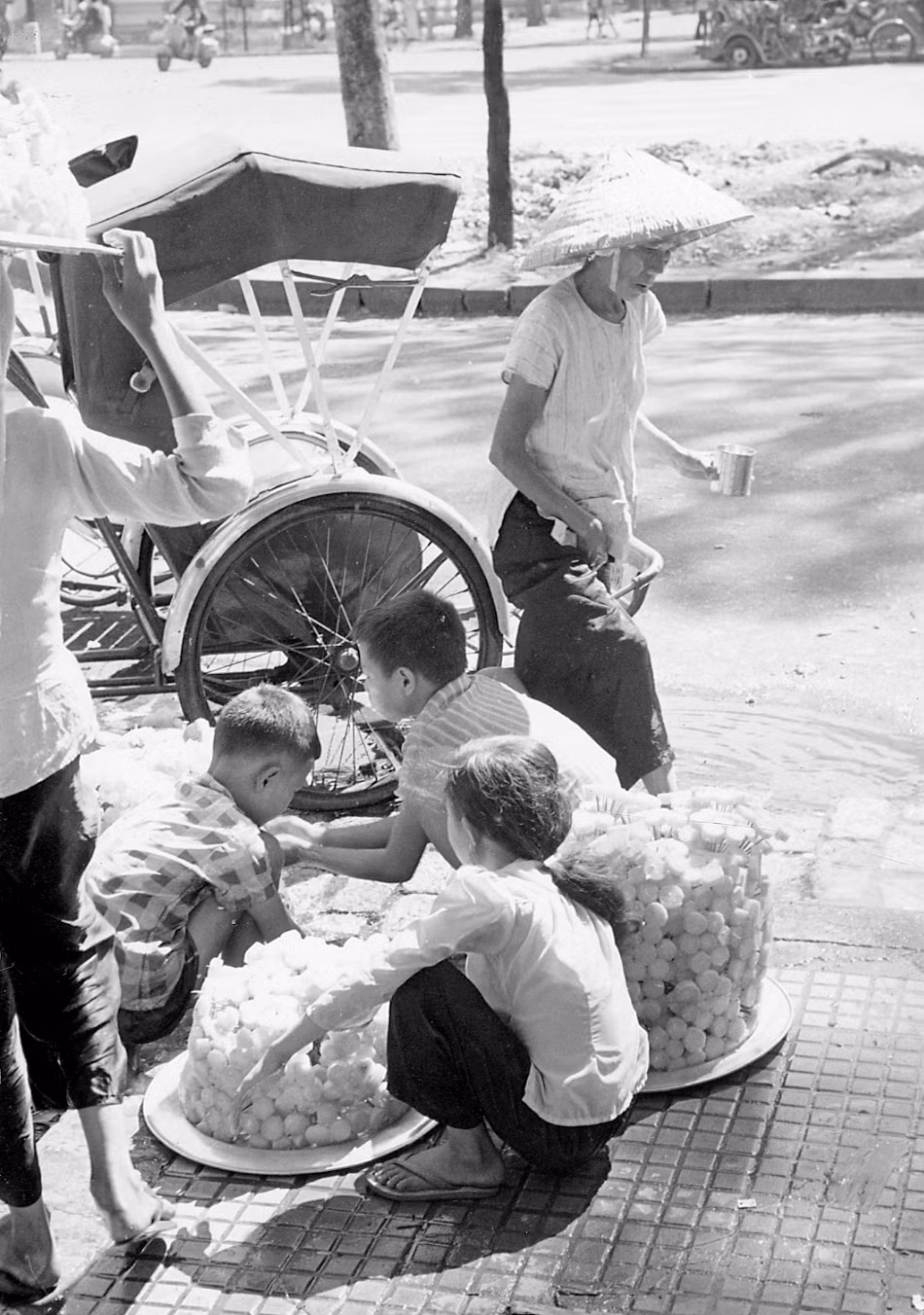 Chiếc xe xích lộ đỗ bên quầy bán mía ghim ở khu vực trung tâm Sài Gòn. Ảnh: Vietnam Center and Archive.