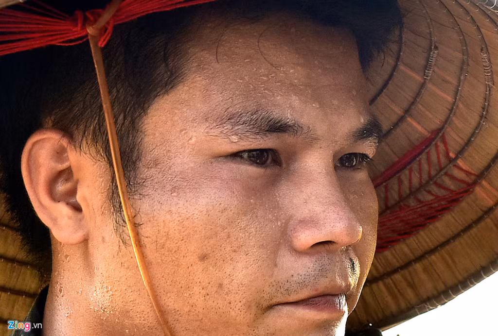 Mồ hôi chảy ròng ròng trên khuôn mặt của một than niên khi gặt lúa dưới nắng nóng tại cánh đồng làng Ngọc Than (Ngọc Mỹ, Quốc Oai, Hà Nội). Ảnh: Việt Hùng.