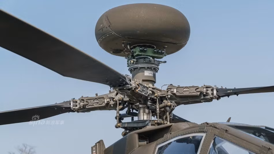 Điểm đặc biệt và dễ nhận ra nhất của Apache AH-64E chính là hệ thống ăng-ten phía trên nóc cánh quạt, hệ thống này cho phép tăng cường khả năng điều phối thông tin cùng với đó là khả năng truyền tải dữ liệu cũng như video theo thời gian thực giữa chiếc Apache và các máy bay không người lái khác trong khu vực. Nguồn ảnh: Sina.