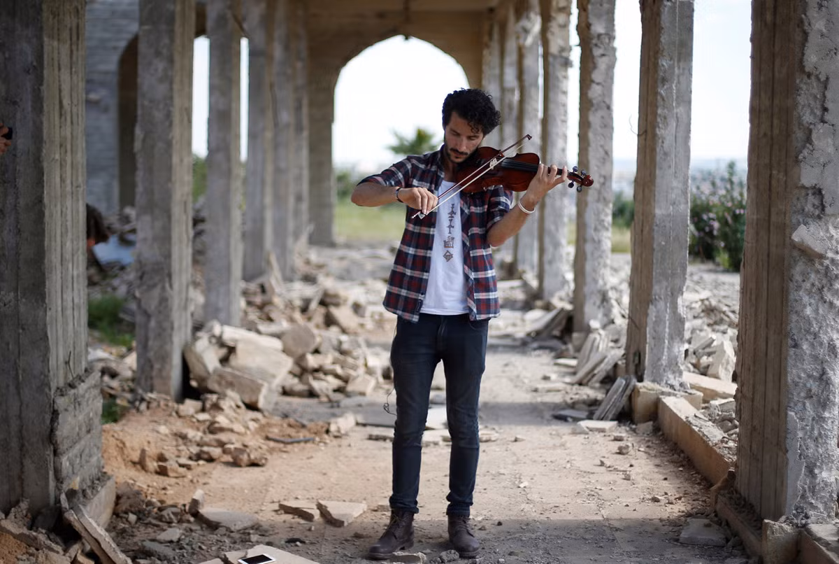 Ameen Mukdad, một nghệ sỹ Violon lần đầu tiên được chơi đàn sau hơn 2 năm rưỡi bị sống dưới sự kèm cặp của IS khi nơi anh ở bị lực lượng khủng bố chiếm giữ. Dưới sự chiếm đóng của IS, cây vĩ cầm của anh đã bị chúng đập nát, quân đội Iraq sau khi giải phóng khu vực của anh đã mang tới tặng anh một cây đàn mới. Nguồn ảnh: Theatlantic.