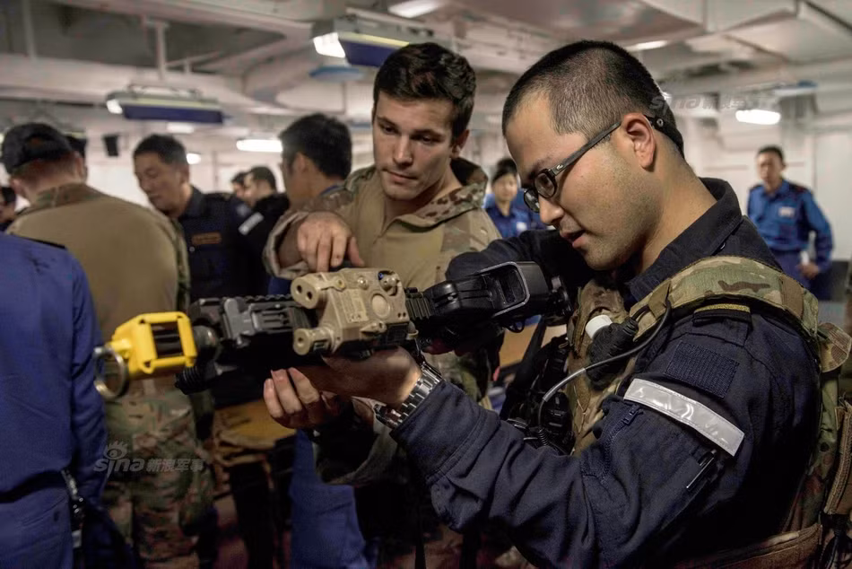 Những khẩu súng trường tấn công được mang ra khỏi kho súng trên tàu sân bay USS Ronald Regan đều được đóng niêm phong vào nòng súng, đảm bảo súng không thể cướp cò, gây tai nạn. Nguồn ảnh: Sina.