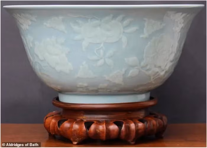 Một phụ nữ người Anh đã tìm thấy một chiếc bát sứ nhỏ màu trắng và xanh lam nhạt khi dọn nhà để chuyển đi. Chiếc bát được chạm khắc tinh xảo với các họa tiết hoa sen, mẫu đơn, cẩm quỳ, cùng những quả thạch lựu, hồng, đào. Nghi ngờ chiếc bát có thể là một ' báu vật', cô mang nó đến một nhà đấu giá ở thành phố Bath, hạt Somerset, Anh để kiểm định.