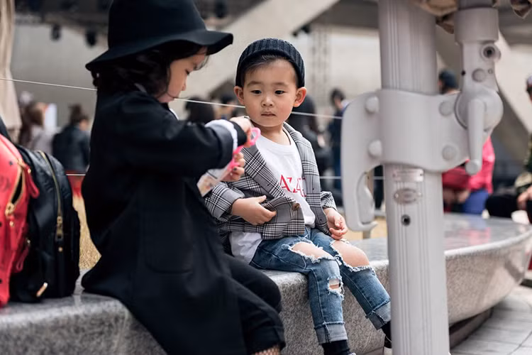 Một bé trai diện mốt jeans rách, kết hợp cùng T-shirt và blazer.