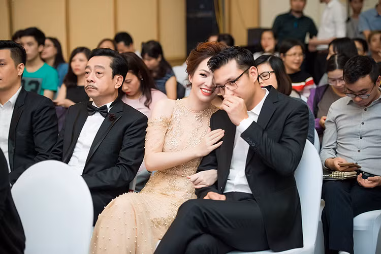 Tại sự kiện, Đan Lê ngồi cạnh Khải Anh. Thỉnh thoảng, nữ MC ghé tai chồng thầm thì rồi mỉm cười rạng rỡ.