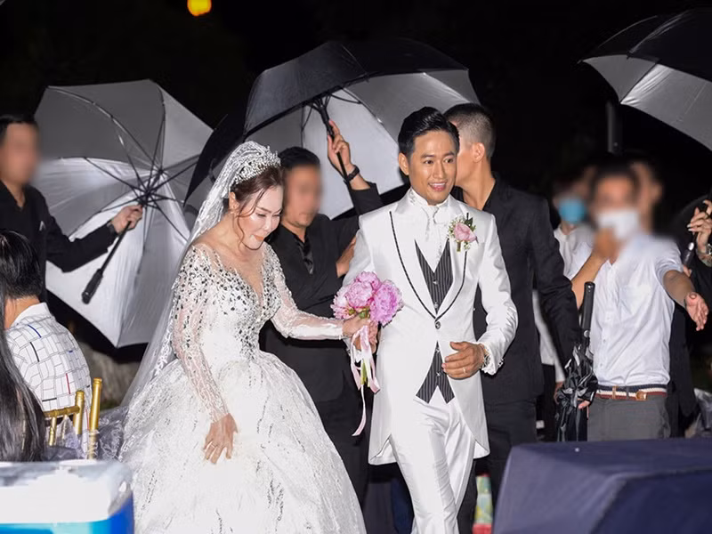 Diễn viên Quý Bình - doanh nhân Ngọc Tiền cũng dùng ô che chắn hình ảnh trong đám cưới. Ảnh: Dân Việt.