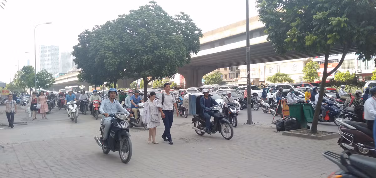 Người đi bộ trên vỉa hè phải đi chung với dòng xe máy phóng bạt mạng.
