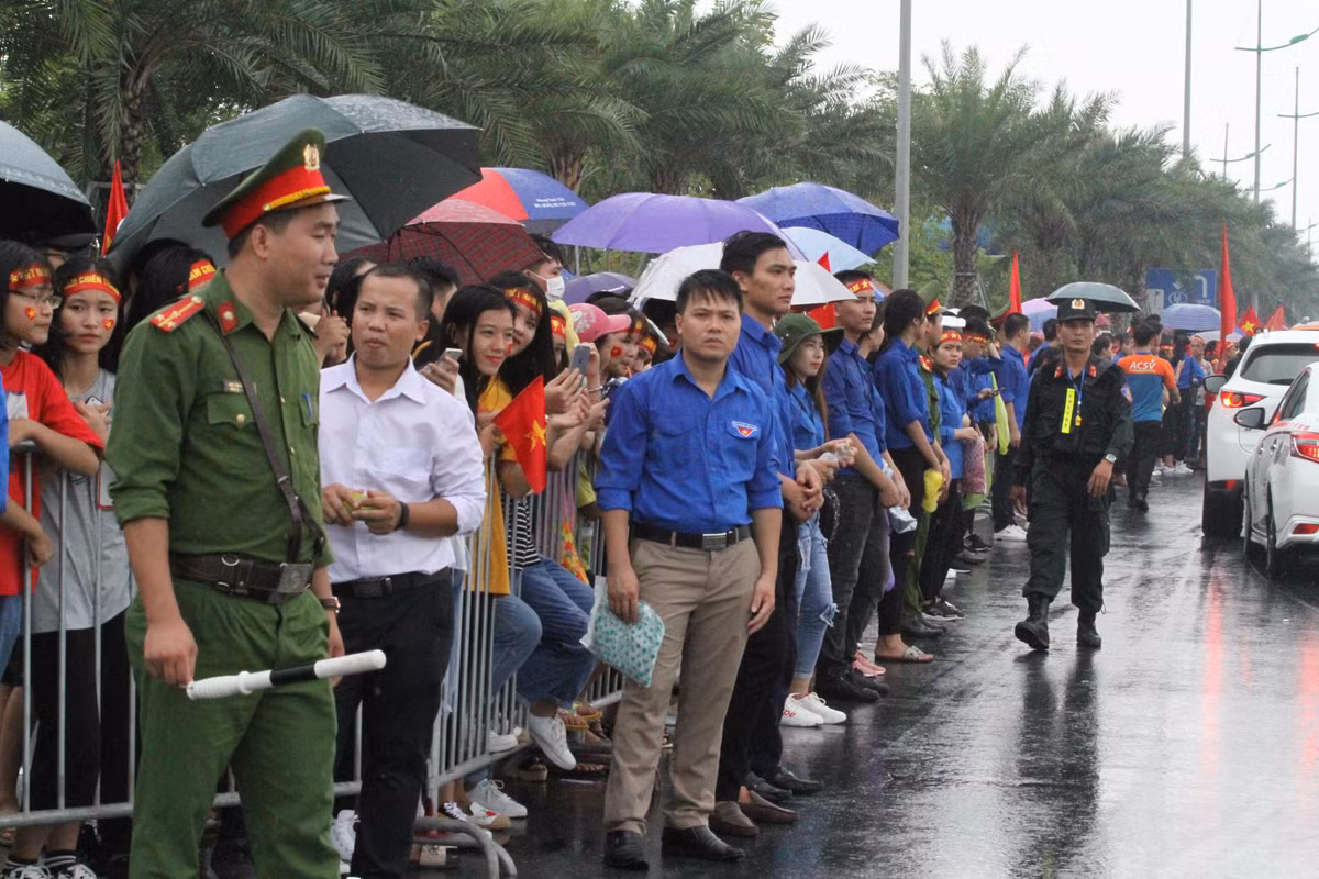 Khu vực sân bay Nội Bài trời bỗng đổ mưa như chút nước, nhưng vẫn không giảm đi sự nhiệt tình chờ đón đoàn đội tuyển thể thao về nước, nhiều người dân dù phải che ô, mặc áo mưa nhưng trên gương mặt không ai thiếu đi sự rạng ngời.