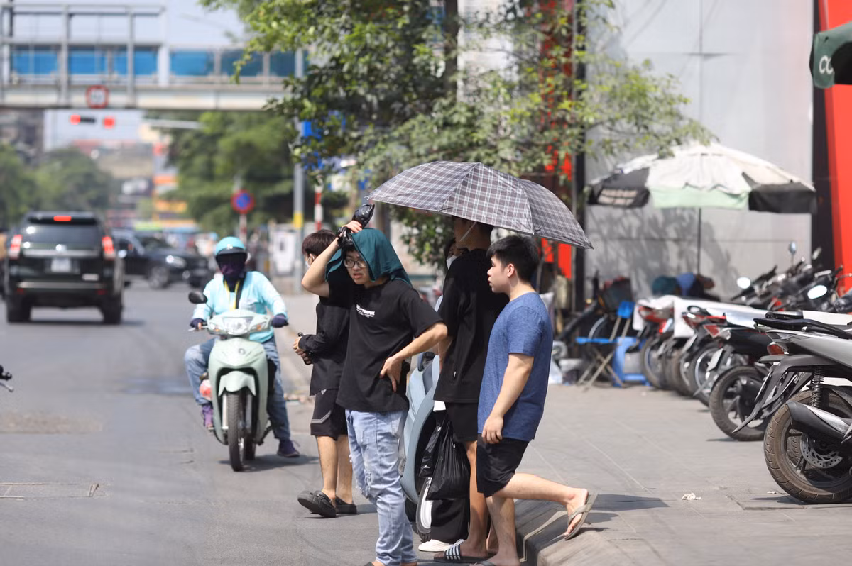 Sử dụng ô dù, hay tiện thể dùng áo trùm đầu cũng là cách mọi người chống nắng nóng.