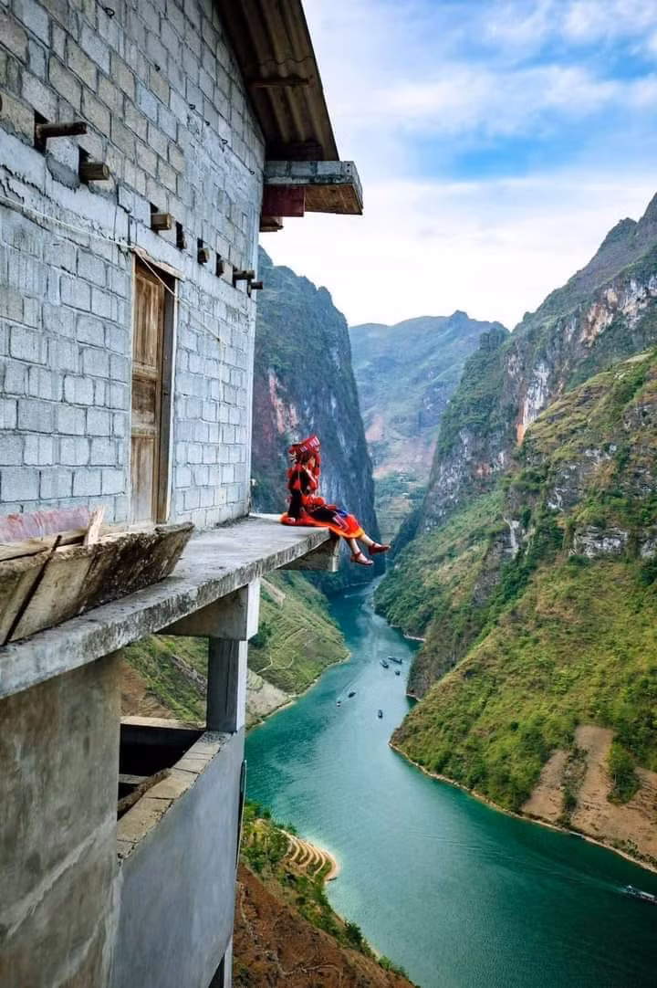 Du khách phải trèo qua một bức tường, đi mon men ven lan can bê tông, rộng khoảng hơn 1m, không rào chắn để đến góc chụp ảnh trên. Ảnh: Trần Tuân