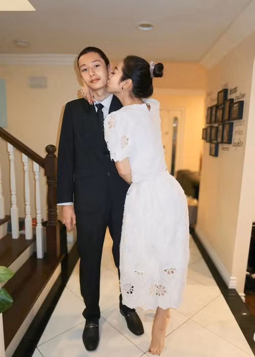 Jennifer Phạm hôn má quý tử trước khi cậu nhóc tham gia bữa tiệc.