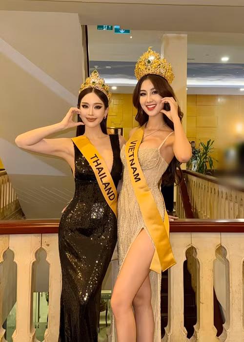 Đại diện Việt Nam mặc váy xẻ tà cao, tự tin đọ vẻ gợi cảm bên đại diện Thái Lan. Ảnh: FB Quế Anh.