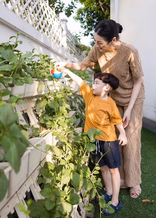 Khoảnh khắc Tú Anh cùng con trai tưới cây. Ảnh: FB Tú Anh.