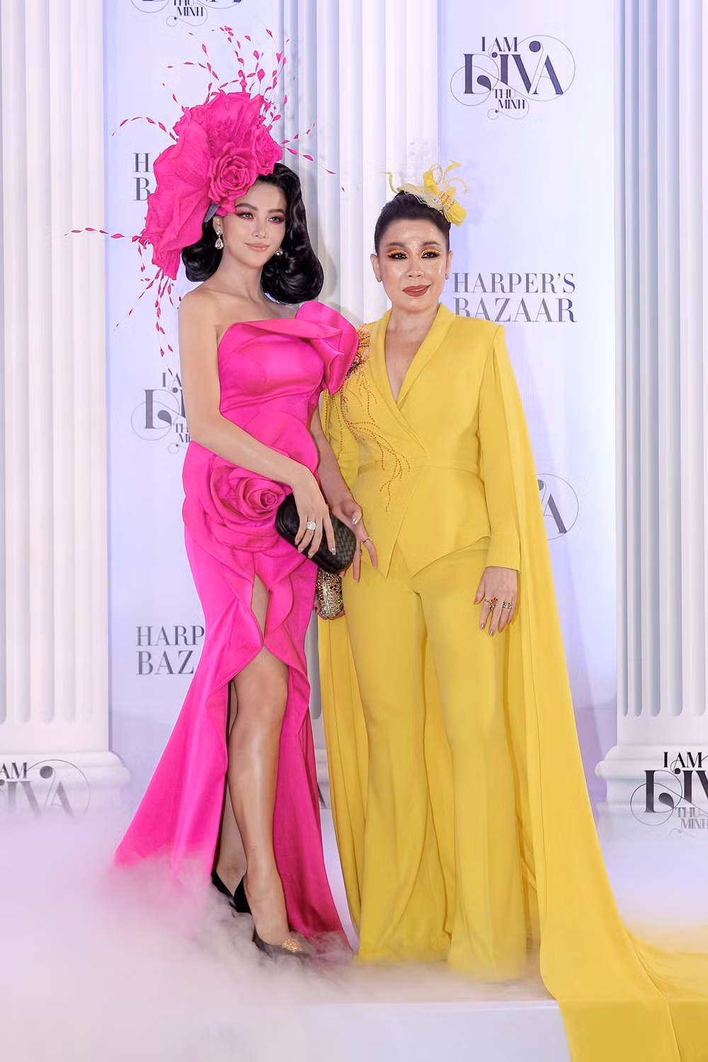 Hoa hậu Phương Khánh rực rỡ trong thiết kế đầm dài xẻ tà màu hồng fuchsia. Đứng cạnh cô là NTK Linh San với bộ cánh màu vàng neon cũng nổi bật không kém.