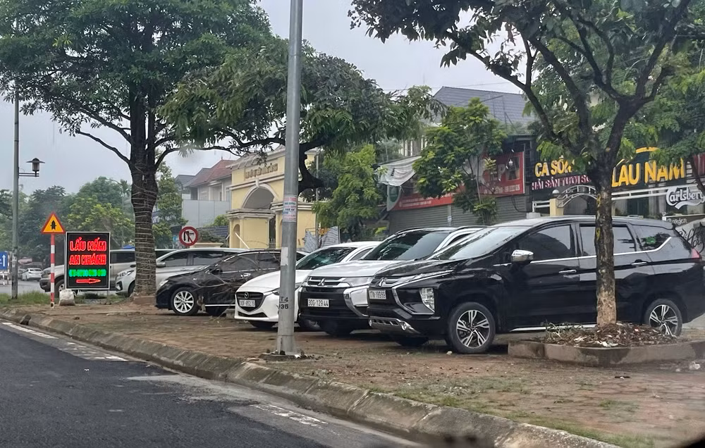 Vỉa hè nằm trước cửa hàng có tên "lẩu nấm An Khánh" bị chiếm trọn làm nơi dừng đỗ xe cho khách.