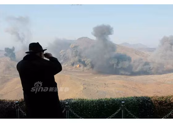 Ông Kim Jong-un cầm ống nhòm quan sát các mục tiêu pháo kích.