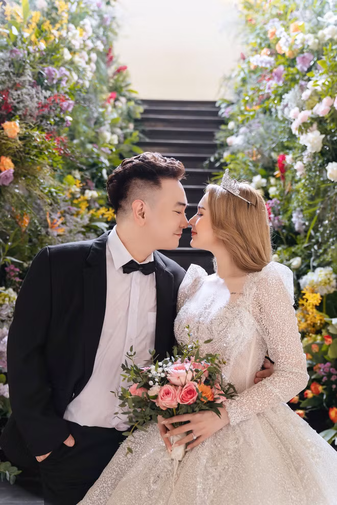 Váy cưới của cô dâu Phạm Trang được lấy ý tưởng từ chiếc váy của nữ hoàng Ravenna. Chiếc váy còn được đính kết theo họa tiết hoàng gia, kết hợp 30.000 viên đá Swarovski ánh bạc và pha lê ánh trắng cực sang.