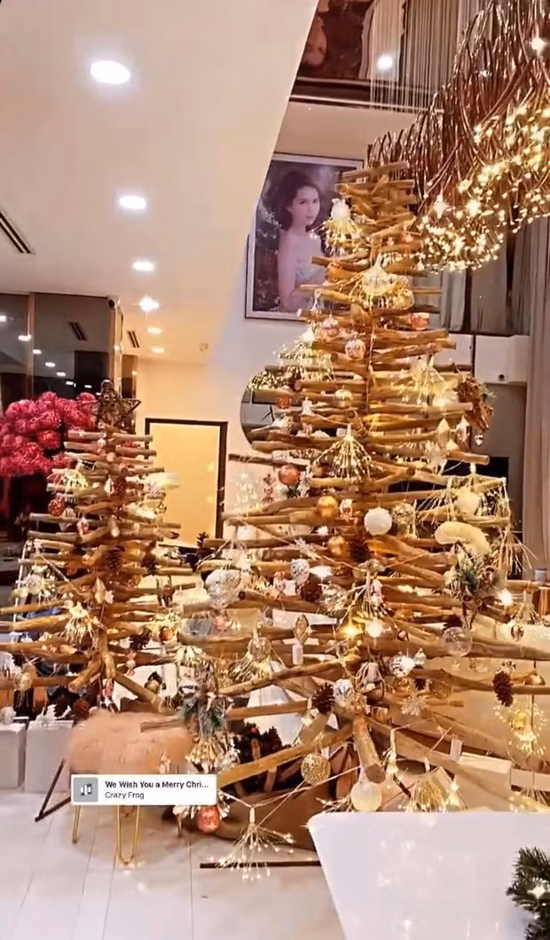 Cây thông Noel cũng đã được trang trí đâu vào đó. Nó dựng từ thanh gỗ, các “tán cây” được ghép từ vật dụng trang trí và có thêm đèn phủ quanh, tất cả đều có màu vàng cực sang chảnh.