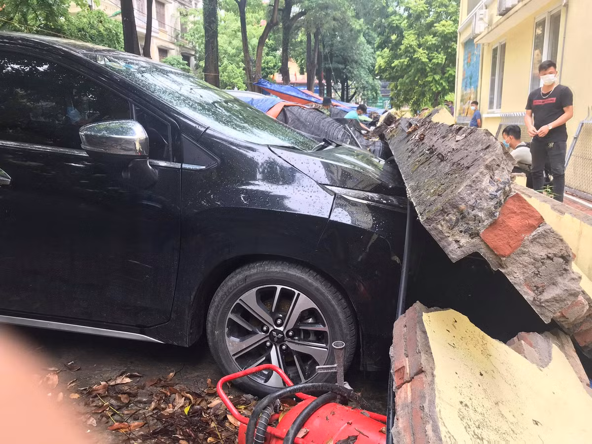 Một bức tường cao 2-3 m dài khoảng 30 m, bất ngờ đổ sập, đè lên nhiều ô tô đang đỗ trên vỉa hè. 